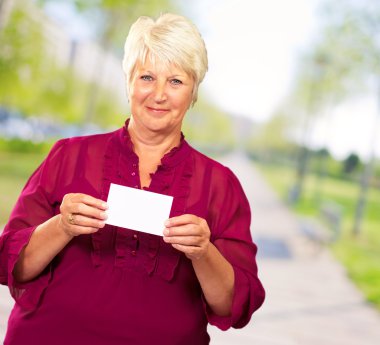 bir kart tutan üst düzey kadın