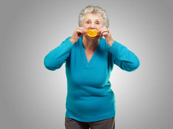 Donna matura con una fetta di frutta — Foto Stock