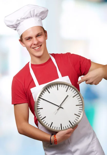 Retrato de un joven sosteniendo un reloj — Foto de Stock