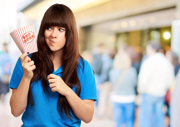 Lány gazdaság üres popcorn csomag — Stock Fotó