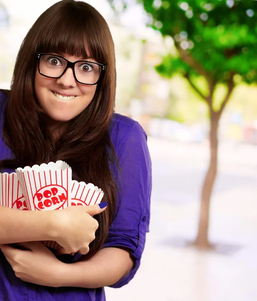 Portret van een jonge vrouw met popcorn container — Stockfoto