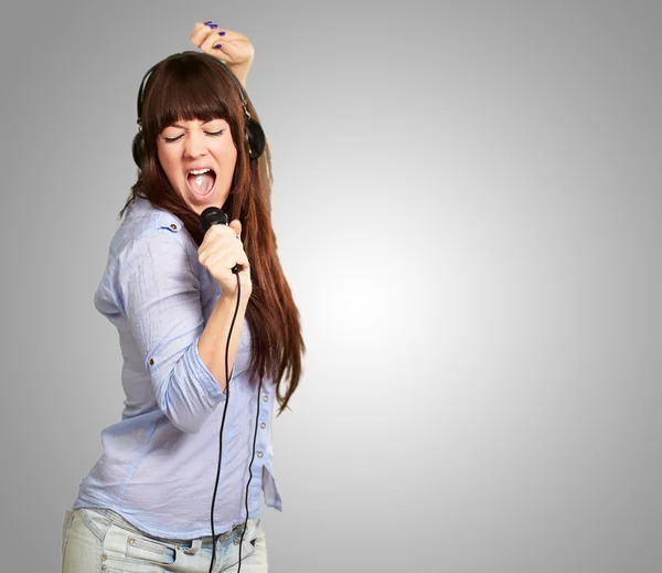 Chica con auriculares cantando en Mike — Foto de Stock