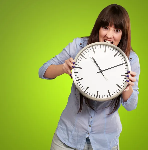 Une jeune fille tenant une horloge et en colère — Photo