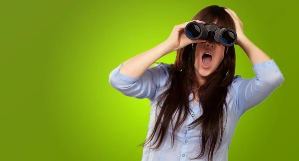 Porträt einer jungen Frau, die durch ein Fernglas blickt — Stockfoto