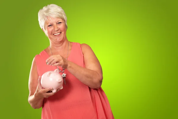 Sênior mulher segurando um piggybank — Fotografia de Stock