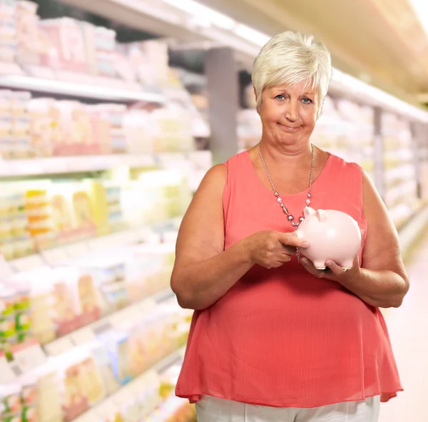 Зрелая женщина держит свинью в банке — стоковое фото