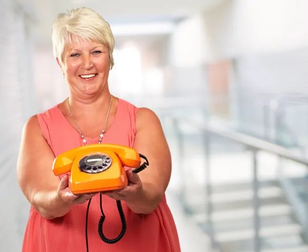 Portret van een senior vrouw met een retro telefoon — Stockfoto