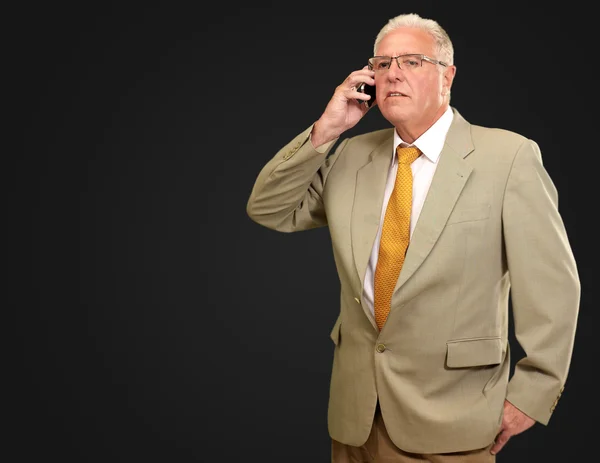 Старший чоловік розмовляє по телефону — стокове фото