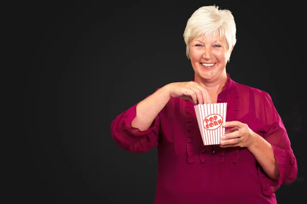 Oude vrouw eten popcorn — Stockfoto