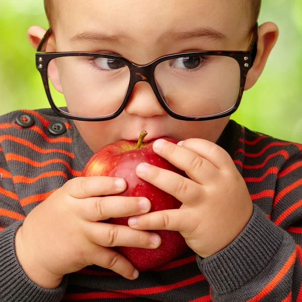 Porträtt av pojke som äter rött äpple — Stockfoto