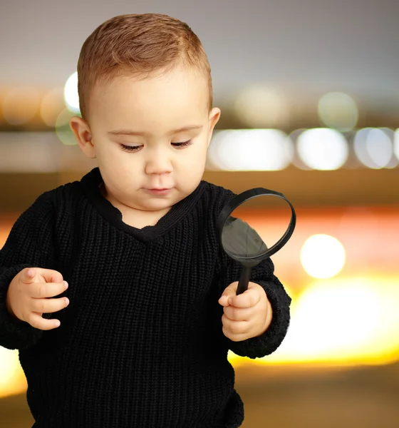 Babyjongen houden een vergrootglas — Stockfoto