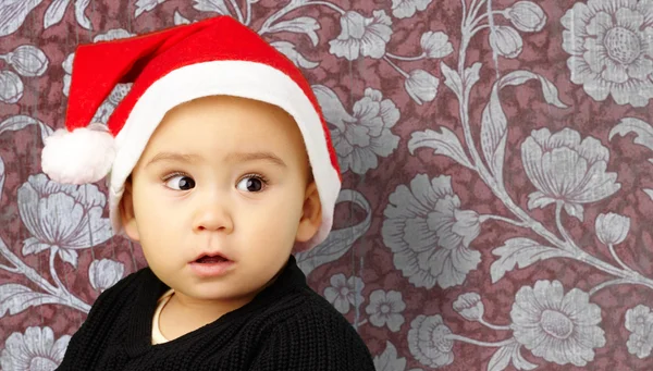 赤ちゃんの男の子のクリスマスの装飾を保持しているサンタ帽子をかぶっています。 — ストック写真