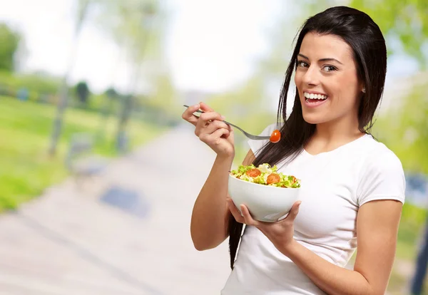Ung flicka äter sallad från skål — Stockfoto