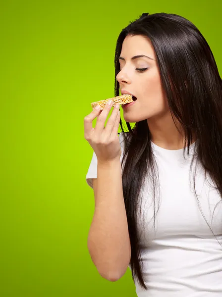 Молодая девушка ест зерновой батончик — стоковое фото
