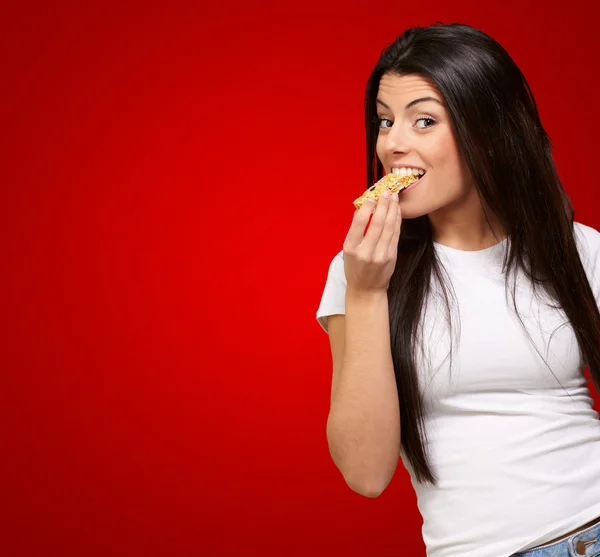 Mulher comendo uma barra de cereais — Fotografia de Stock