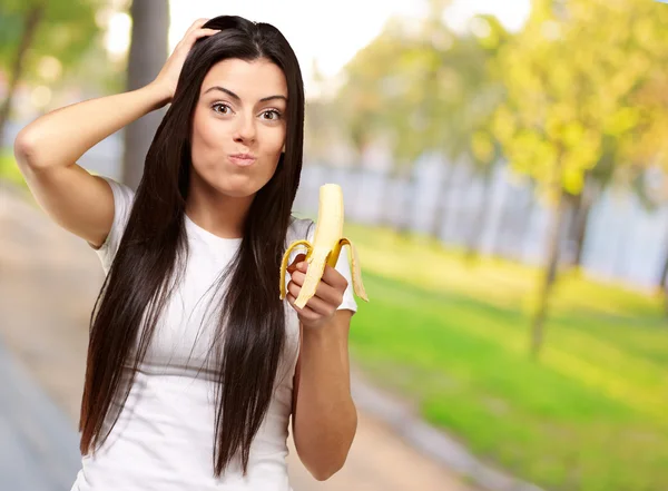Eine junge Frau isst eine Banane — Stockfoto