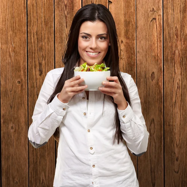 Ung flicka visar en skål med sallad — Stockfoto
