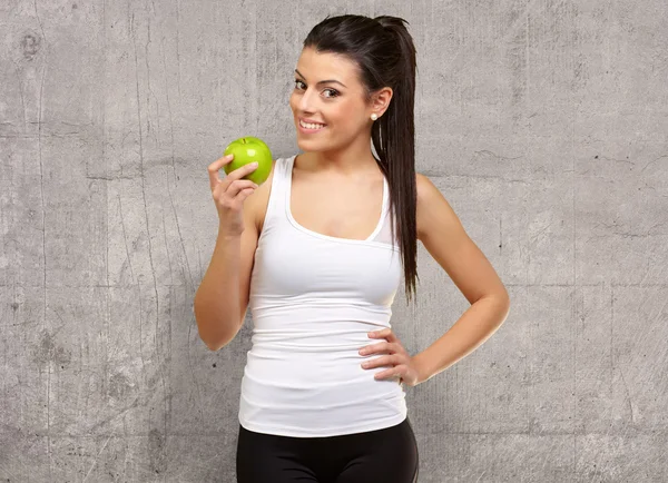 Junge Frau hält und isst einen Apfel — Stockfoto