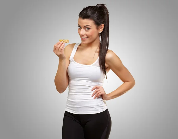 Una joven comiendo una barra de granola — Foto de Stock