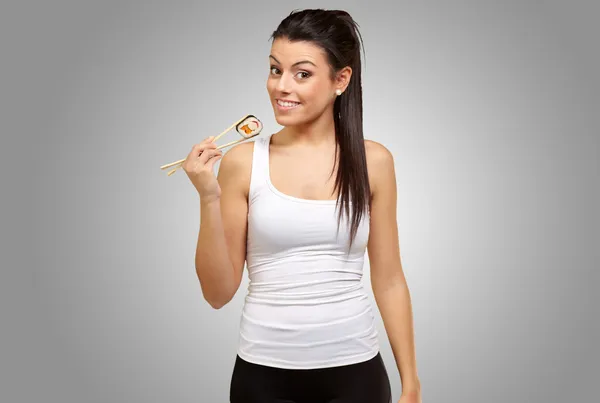 Young girl Holding Sushi Roll with chopsticks — Stock Photo, Image