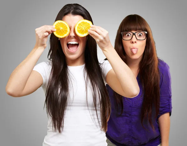 Mujer joven sosteniendo rebanada de naranja —  Fotos de Stock