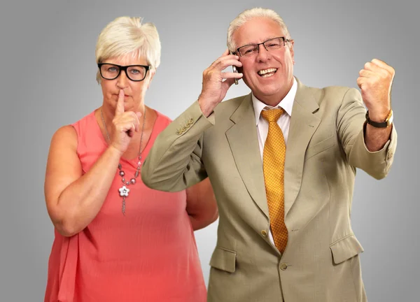 Uomo assunzione su cellulare di fronte a donna gesturing — Foto Stock