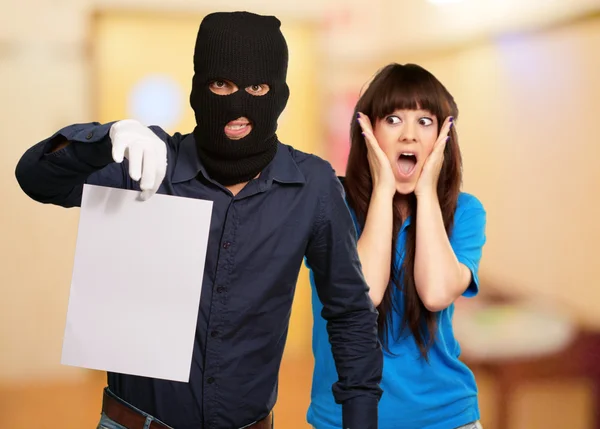 Homme cambrioleur tenant du papier devant une femme effrayée — Photo