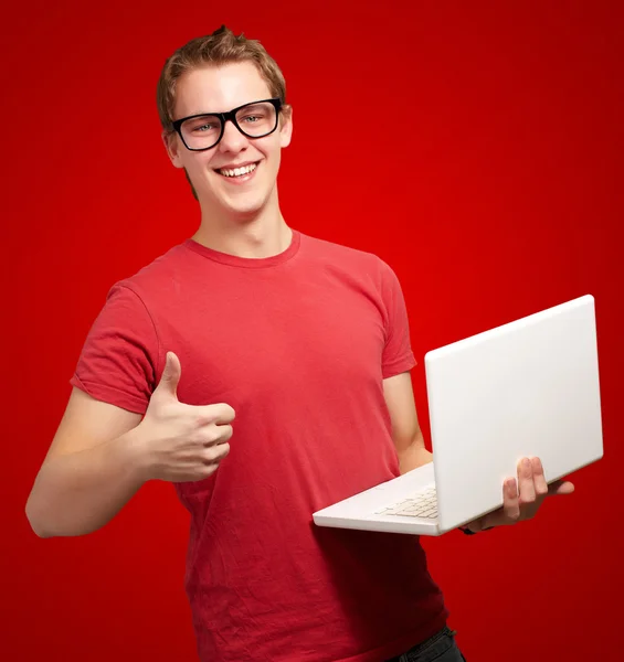 Man holding laptop with thumbs up Stock Picture