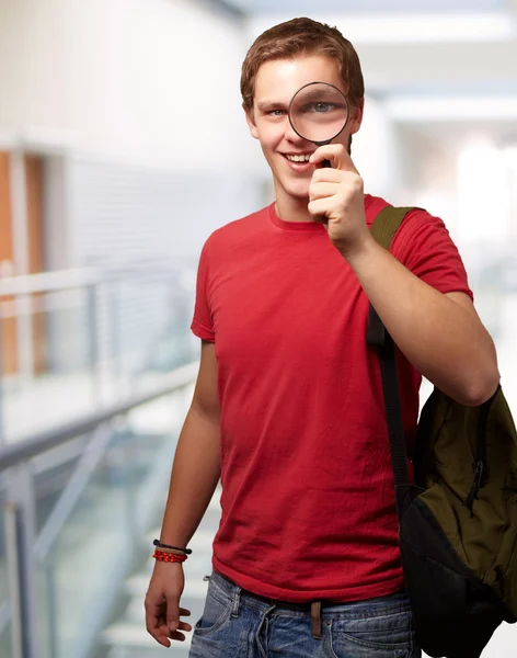 Porträt einer Studentin, die durch die Lupe schaut lizenzfreie Stockbilder