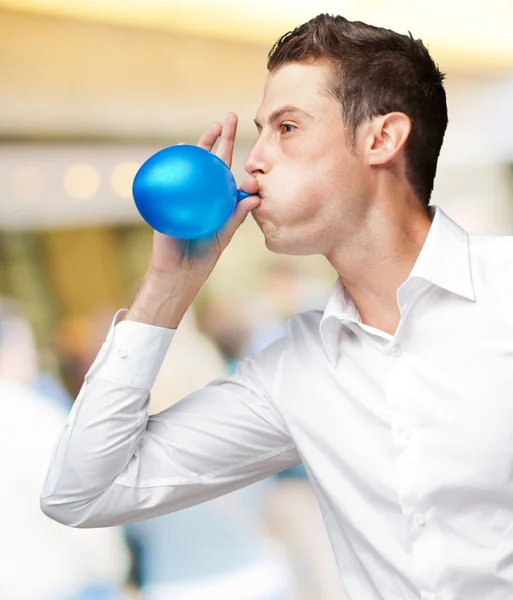 Porträtt av ung man blåser ballong — Stockfoto