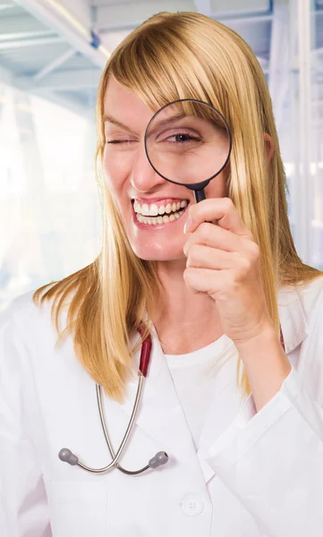 Médico feliz olhando através de lupa — Fotografia de Stock