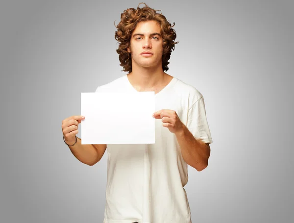 Jovem homem casual segurando uma mensagem em branco — Fotografia de Stock