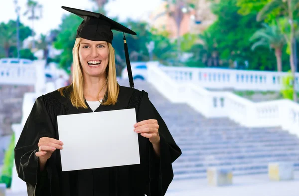 Graduada mujer sosteniendo un papel en blanco —  Fotos de Stock