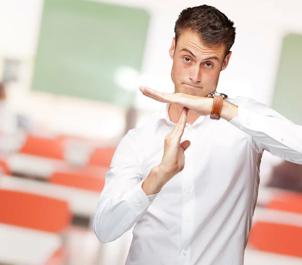 Porträtt av ung man gestikulerar time out tecken — Stockfoto