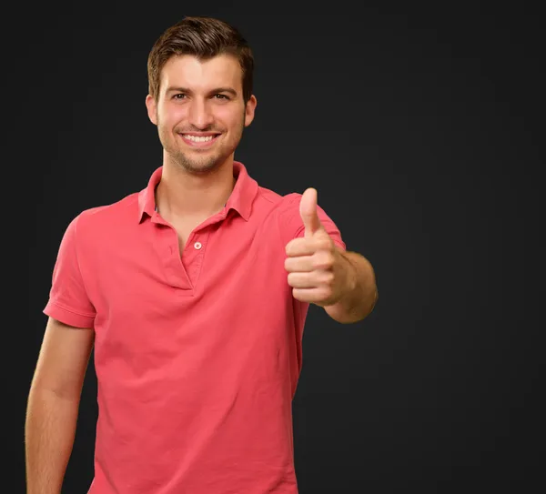 Giovane uomo sorridente con i pollici in su — Foto Stock