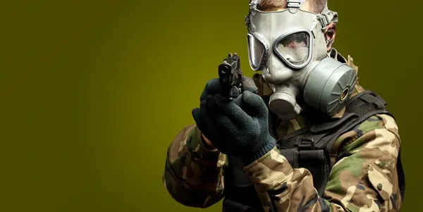 Portrait d'un soldat avec masque à gaz visant avec un pistolet — Photo