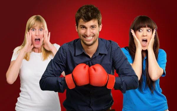 Uomo con guanti da boxe e donna spaventata in piedi dietro — Foto Stock