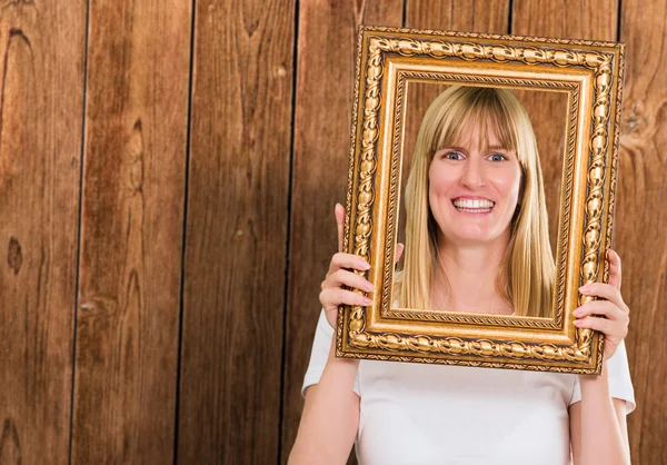 Retrato de una mujer feliz sosteniendo el marco — Foto de Stock