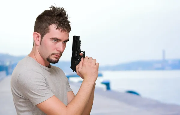 Homem concentrado segurando arma — Fotografia de Stock