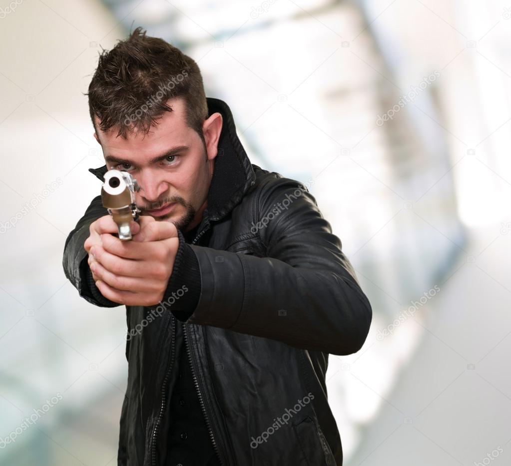 young man pointing with gun