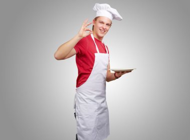 gri bir arka plan karşı genç aşçı adam portresi