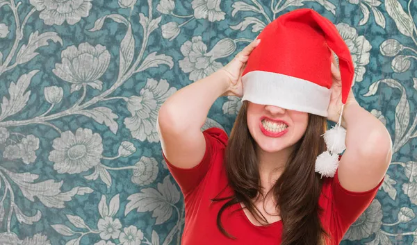 Boos vrouw met een kerstmuts die betrekking hebben op haar ogen — Stockfoto