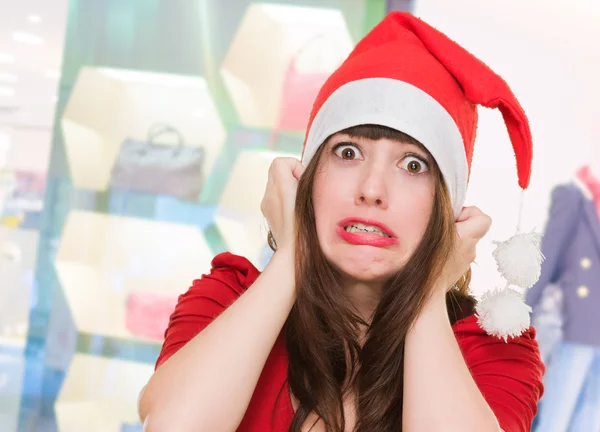 Scared woman wearing a christmas hat — Stock Photo, Image