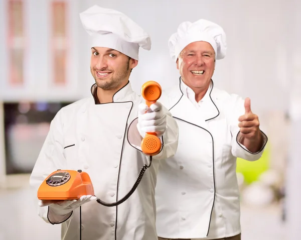 Jovem Chef Segurando Telefone Na Frente Do Chef Maduro — Fotografia de Stock