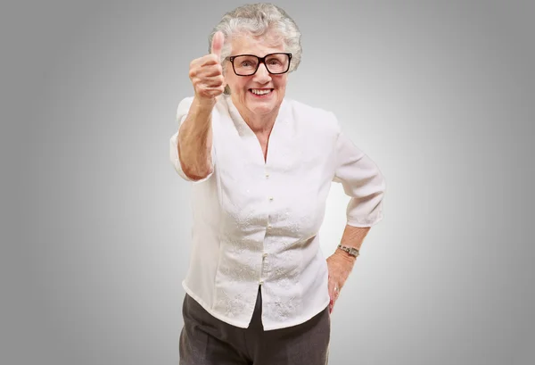 Porträt einer entzückenden Seniorin, die gute Geste über Grau macht — Stockfoto