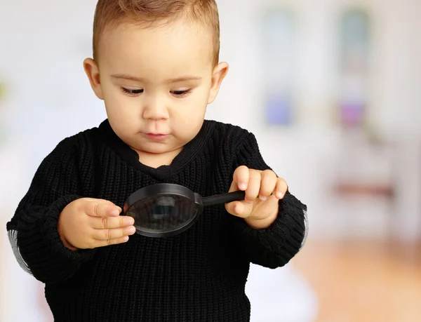 Bebê menino olhando para lupa — Fotografia de Stock