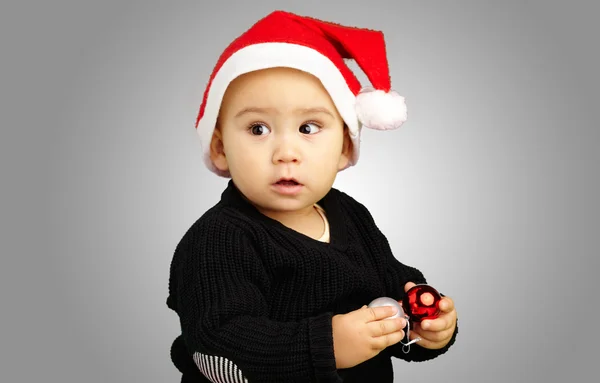 Chlapeček klobouk santa drží vánoční ozdoby — Stock fotografie