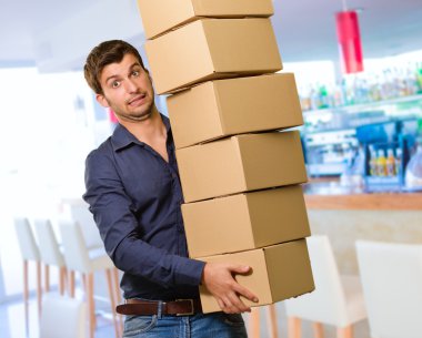 cardboxes yığını tutan genç adam