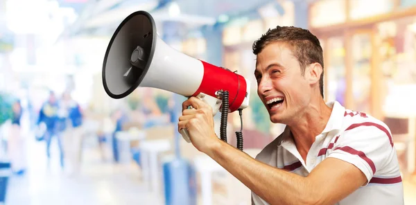 Портрет красивого молодого человека, кричащего с мегафоном — стоковое фото