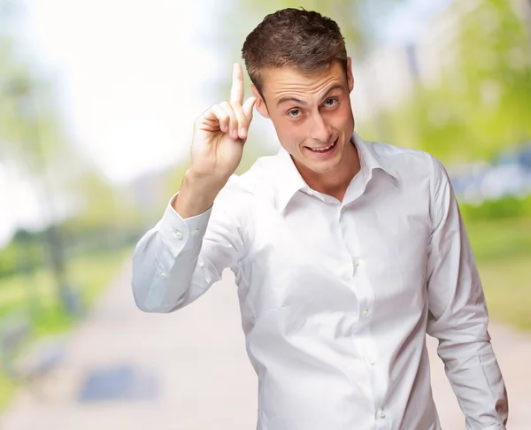 Portrait de jeune homme souriant pointant vers le haut — Photo